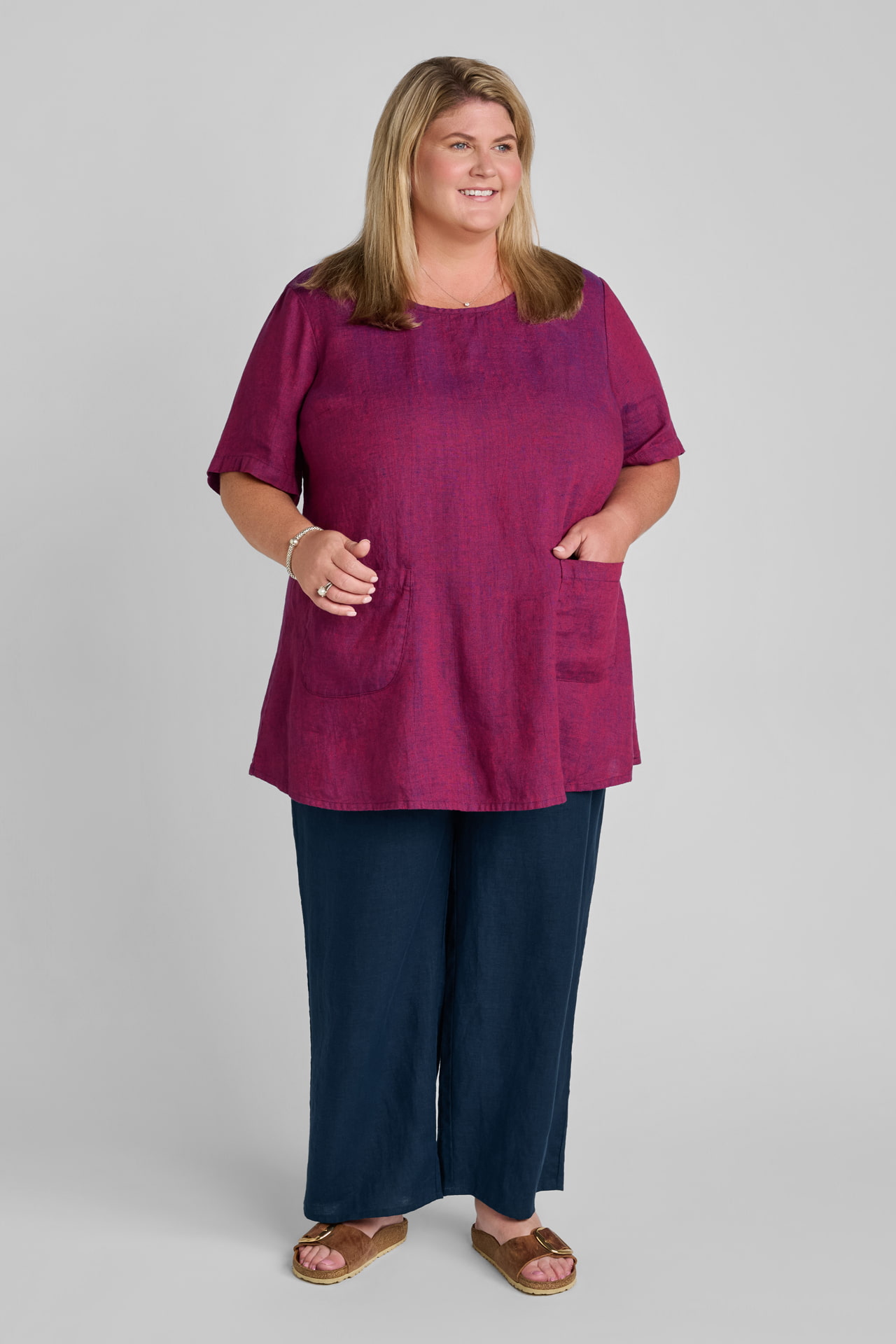 Woman in red linen tank tunic with pockets and blue linen pants